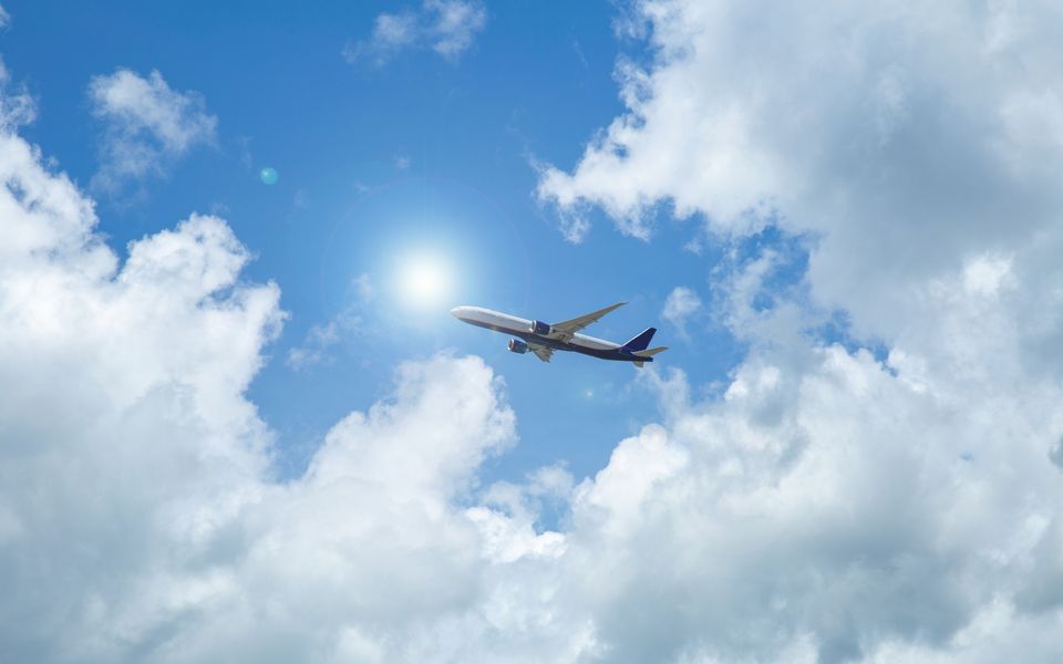 青空と白い雲へ飛び立つ飛行機